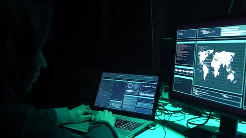 Hooded Hacker Typing Code in a Dark Room