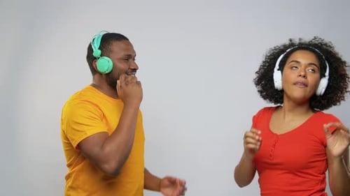 Man and woman listen to music with headphones