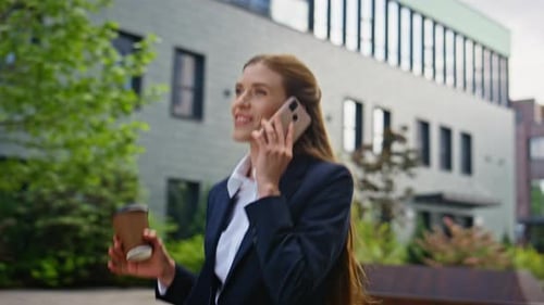Smiling Businesswoman Talking on Phone Walking Outdoors