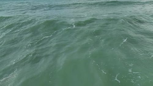 Aerial Video Powerful Ocean Waves and Swirling Foam Transform the Sandy Coastline During a Storm