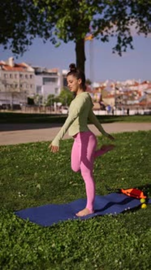 A Woman is Practicing Yoga in a Peaceful Park Surrounded By Nature Under the Sunlight