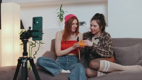 Two Young Adults Vlogging with Toy Camera on Couch