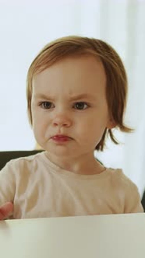 Toddler Eating and Making Funny Face at Table