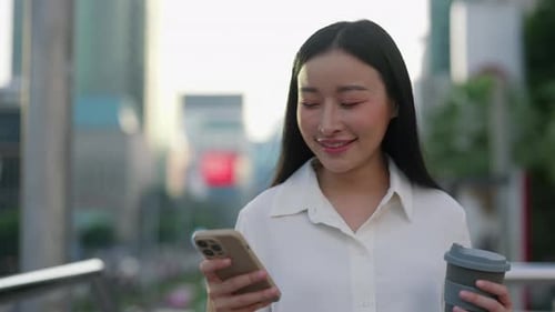 Woman Using Phone on City Street