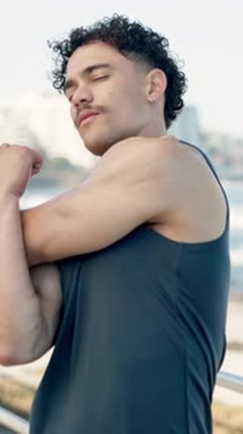 Stretching, fitness and man by beach for running, workout or wellness training on promenade