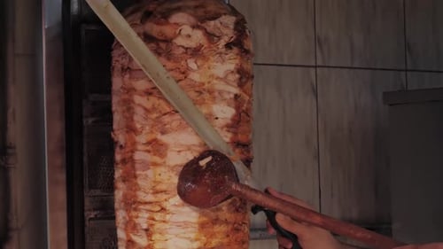 Man with a Big Knife Cooks a Doner Kebab Meat Shawarma on Walking Street in Istanbul Turkey