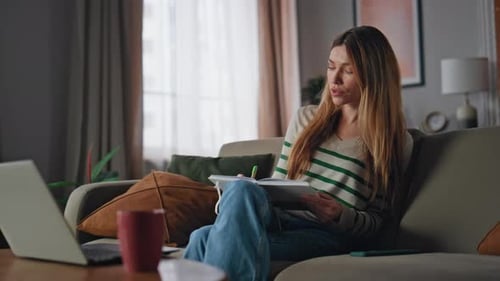 Woman with Laptop Taking Notes at Home