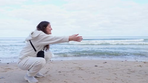 Mother with Hands Apart on Beach Calls Daughter to Come