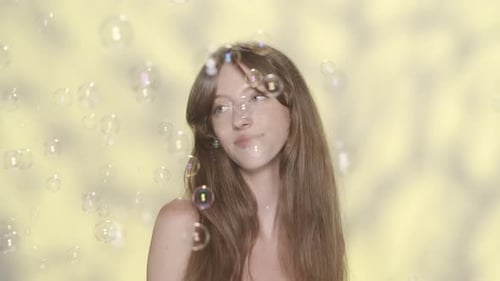Beautiful Woman Surrounded by Floating Soap Bubbles