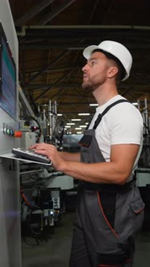Engineer Working at Programmable CNC Machine in Factory Industries