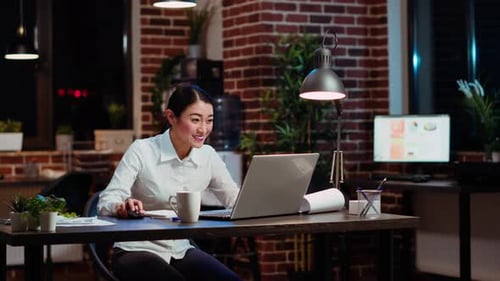 Cheerful Woman Celebrating Success in Office at Night