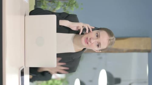 Professional Woman Talking on Phone at Desk
