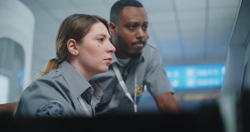 Man and Woman Discuss Computer Screen in Uniform