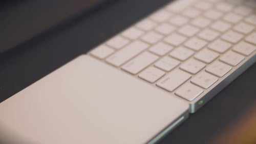 Nahaufnahmen bewegter Nahaufnahmen einer modernen Tastatur und eines Trackpads mit progressiver und nachdenklicher Atmosphäre