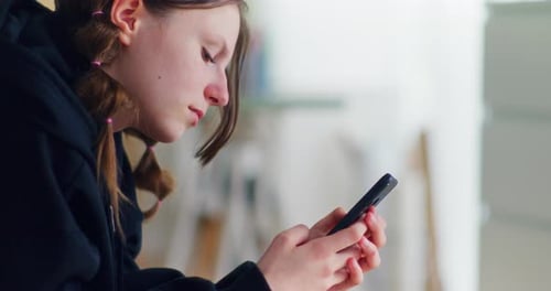 Teen Using Mobile Phone Indoors at Home