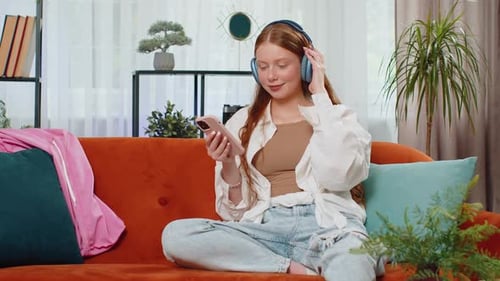 Red-Haired Woman Listening to Music at Home