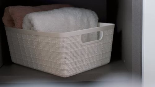 Serviettes dans des contenants en plastique dans le placard, vue de face, concept d'organisation de l'espace.