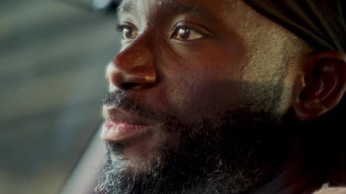 Afroamerikanischer Mann in Durag spricht mit Freunden im Auto