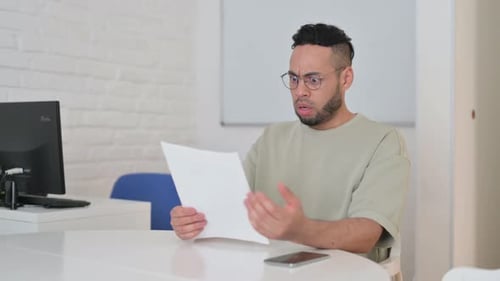 Man Reads Documents with a Confused Expression
