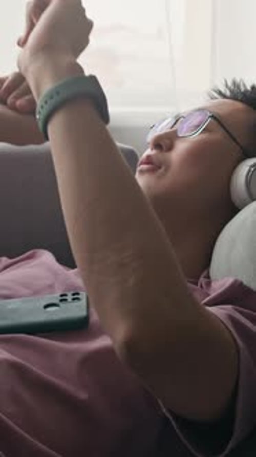 Man Lying on Couch Listening to Music
