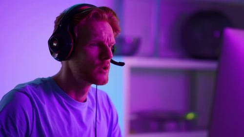 Young Man Gamer with Headset Talking During Gameplay