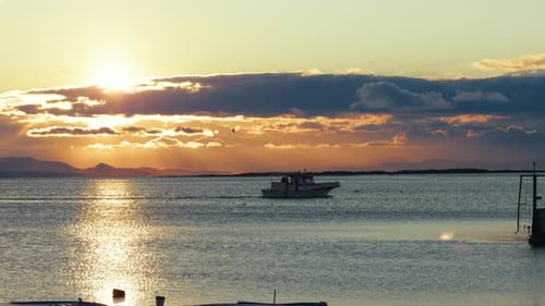 Lonely Fishing Boat Sailing Through Golden Sunset Light