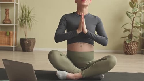 Pregnant Woman Meditating at Home in Yoga Position