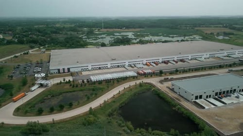 Warehouse with Semi Trucks and Cargo Trailers Aerial Wide View