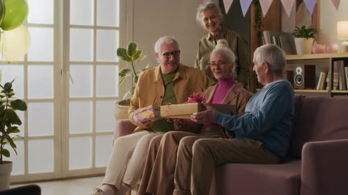 Seniors Celebrating Birthday Party with Gifts and Balloons