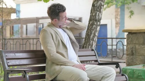 Man Relaxes on a Bench in the Park