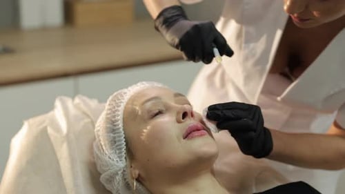 Cosmetologist Performing Nasolabial Folds Filler Injection on Woman