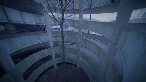 Furchtlose Frau mit Kapuze, die in der Abenddämmerung in einer verlassenen Stadtstadt spaziert