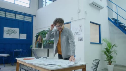 Male Architect Working with Floor Plan in Office
