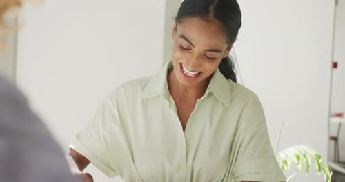 Happy diverse couple drinking coffee and talking at a table in a cafe