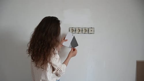 Woman Selecting Paint Color Swatches for Home Makeover Project