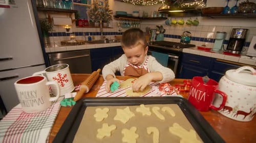 Boy Baking Christmas Cookies in Kitchen