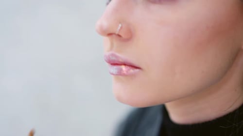 Woman Applying Gloss to the Lips with a Brush