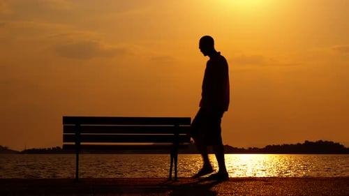 Silhouette Sitting on a Bench at Sunset