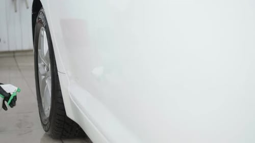 Worker in Garage Automobile Service is Applying Detergent