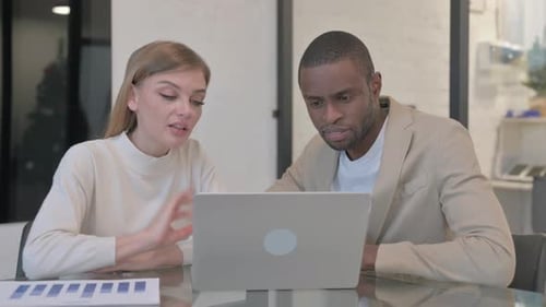 Professionals Collaborating at Laptop in Bright Office