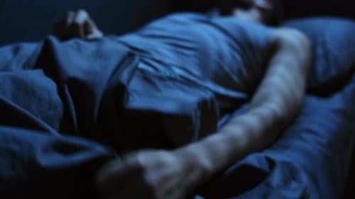 Adult Sleepless in a Dark Bedroom at Night