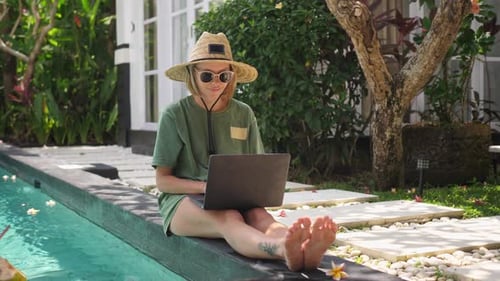 Woman Working on Laptop by Tropical Villa Pool