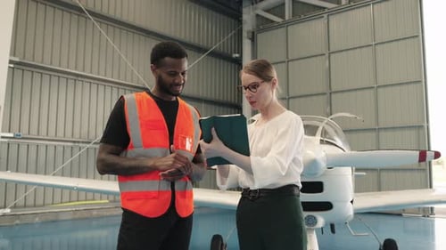 Der Chef der Flugzeugwartung bespricht die Flugzeug-Checkliste mit dem Piloten in Zeitlupe