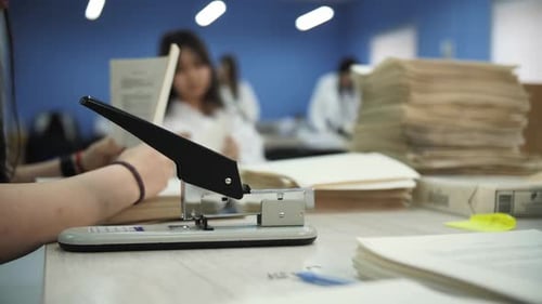 Office Worker Punching Holes in Documents