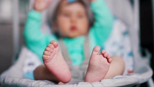 Close Up of Adorable Baby's Feet in Bouncer