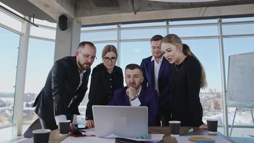 Business Team Collaborating Around Laptop in Modern Office