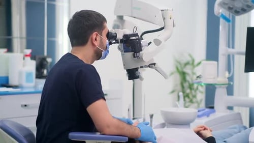 Dentist Using Microscope in Modern Dental Clinic