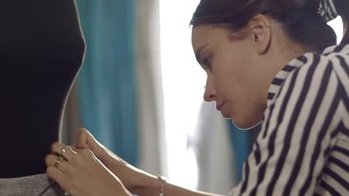 Close up of Young female fashion designer working at home studio.