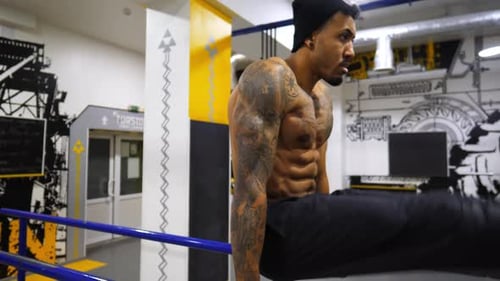 Strong Black Guy Training Abdominal Muscles on Parallel Bars at Gym Afro American Sportsman