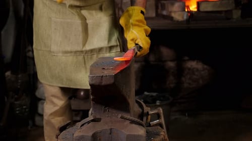 Blacksmith Hammering Red Hot Metal on Anvil